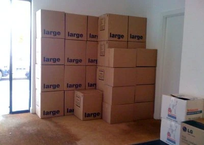 A stack of cardboard boxes labeled "large" in a room, with a doorway and other boxes visible in the foreground.
