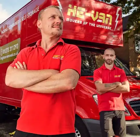 Two men in red branded shirts stand confidently in front of a moving truck, promoting a moving and storage service.